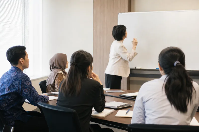 日本語講師がアジア系の外国人受講者にN2合格に向けた日本語研修を行う様子（業務委託・パッケージ研修）